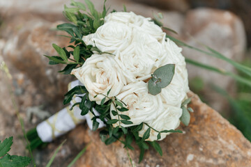 Bride's bouquet of white roses on a stone surface close-up