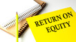 RETURN ON EQUITY text written on a yellow paper with notebook