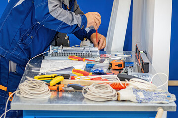 Poster - production of electrical equipment. man with screwdriver is repairing electrical appliance. wires an