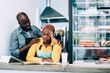 © BullRun - Pensive ethnic adult man consoling sad business partner while working in cafe