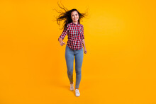Full Length Photo Of Active Optimistic Person With Fluttering Hair Wear Plaid Shirt Jeans Go Shopping Isolated On Yellow Background