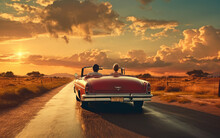 Lovers Traveling In A Convertible Drive On The Highway At Sunset