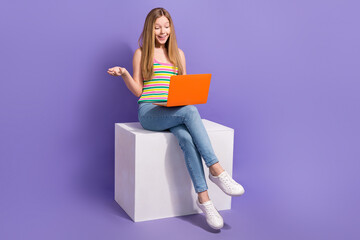 Sticker - Full size photo of pretty teenager blonde girl sit cube video call netbook wear trendy striped outfit isolated on purple color background