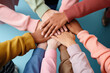 Collaboration and Teamwork: A group of diverse people huddled together, each placing their hand on top of one another’s in a unified gesture - AI Generated