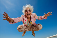 Old Woman Jumping In The Air With Her Arms Out And Smile On Her Face.