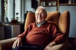 Elderly man in burgundy armchair watching TV in his room - middle shot portrait