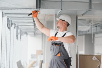 hvac services - worker install ducted pipe system for ventilation and air conditioning in office.