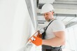 © Serhii - The builder fills the seam between plasterboard plates a silicone gun