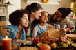 © Drazen - Happy multiracial family enjoys on Thanksgiving at dining table.