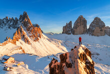 Rear View Of A Hiker Admiring Tre Cime Di Lavaredo (Lavaredo Peaks) (Drei Zinnen) From The Top Of A Giant Rock, Winter View, Sesto (Sexten), Dolomites, South Tyrol