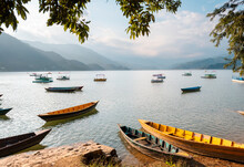 Colourful Boats In Front Of Himalayan Peaks On Lake Pokhara In Pokhara, Nepal