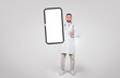 © Prostock-studio - Doctor holding giant smartphone, giving thumbs up