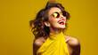 A stylish girl with bright yellow sunglasses and a bold lipstick stands against a vibrant wall, radiating confidence and fashion-forward energy