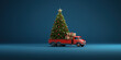 Old truck arriving with fresh Christmas tree on dark blue background with copy space