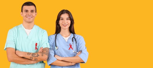 Sticker - Young doctors with red ribbons on yellow background with space for text. World AIDS Day