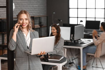 Wall Mural - Female technical support agent with laptop in office