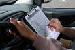 Driving school. Student passing driving test with examiner in car, closeup
