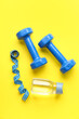 © Pixel-Shot - Dumbbells, measuring tape and bottle of water on color background