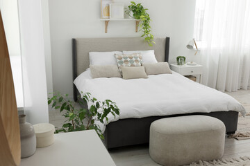 Sticker - Stylish bedroom interior with large comfortable bed, ottoman and bedside table