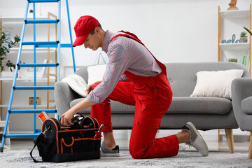 Poster - Male technician taking tools to fix air conditioner in room