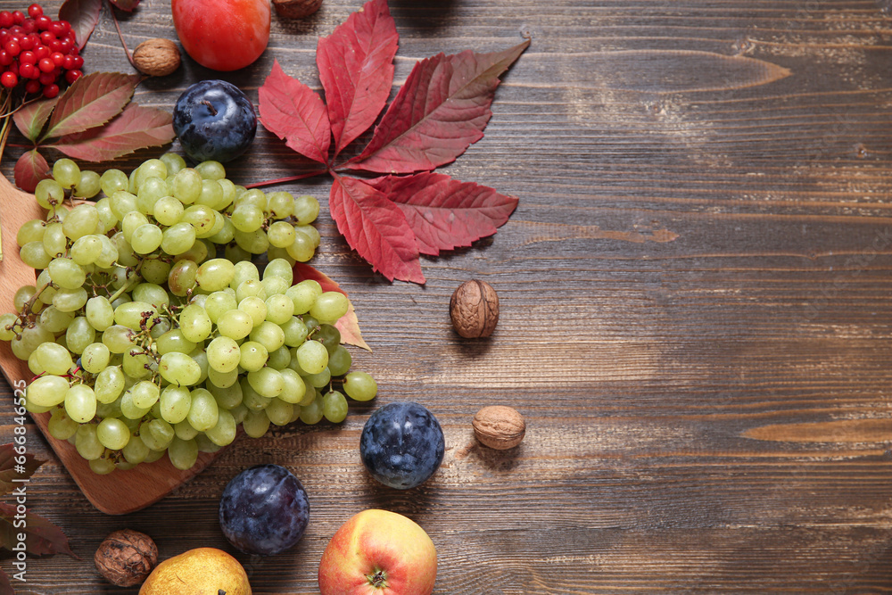 Board with different fresh fruits on wooden background