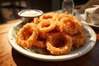 A bowl of onion rings with a side of ranch dressing