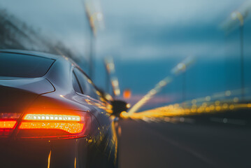 The automobile accelerates quickly at night. blurry road with lights while a fast-moving automobile is on it.