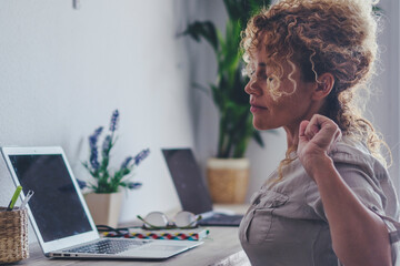 One woman freelance stretching back and neck after laptop work session. Finish project. Tired female people expression and posture for overwork. Small business concept lifestyle indoor leisure job