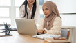 © bongkarn - A beautiful Asian-Muslim businesswoman in a hijab co-working with her colleague in the office.