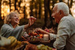 © bernardbodo - Elderly married couple eating grapes at picnic