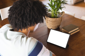 Wall Mural - African american man spending time in log cabin and having tablet video call with copy space