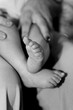 © Wirestock - there is a baby holding its mother's hand as the father puts it on