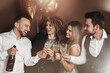 © blackday - Group of elegantly dressed people celebrating a holiday or event, drinking sparkling wine
