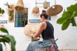 Rear view of Hispanic woman weaving a basket with esparto fibers. Manual work, tradition and culture.