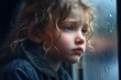 © ana - A sad blond girl child looking out of a window. raining. rain drops. blue eyes.