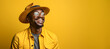 Portrait of handsome afro man wearing hat, eyeglasses on a yellow background