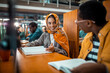 © Marko Geber - Young Muslim woman talking to a friend in a university library