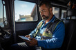 Portrait of a driver sitting in a van and using a tablet