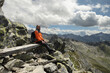 © Guzel - Gray-haired man with backpack reached the top, sitting on a bench and enjoying a beautiful view, Austria