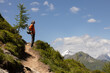 © Guzel - Gray-haired long-haired man standing on the trail to the top against the background of snowy mountains, Austria
