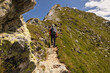 © Guzel - Man on a difficult stretch of rocky road to the top with a cross on the background of the sky, Austria