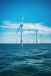 Offshore wind turbines are part of renewable and clean energy in choppy day ocean background