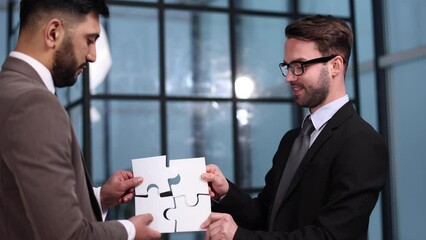 Wall Mural - two businessmen put together a puzzle opposite each other