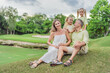 © galitskaya - A happy family, two girls, dad, and a pregnant mom, enjoys quality time together on a lush green lawn, creating cherished memories of togetherness