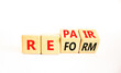© Dzmitry - Reform and repair symbol. Concept words Reform Repair on wooden block. Beautiful white table white background. Business reform and repair concept. Copy space.