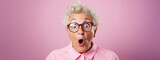 Fototapeta  - Studio portrait of elderly granny wearing glasses, pink background, shocked and surprised expression