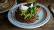 Photograph of avocado toast on a white plate, an appetising and fancy dish.  