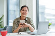 © mojo_cp - Businesswoman use smartphone and laptop with technology to working about calculation tax in office..
