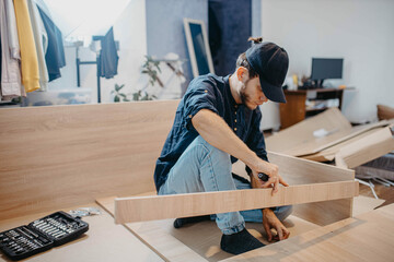 Wall Mural - man assembling furniture wooden cabinet at home