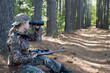 Beautiful young hunter girl looking through binoculars